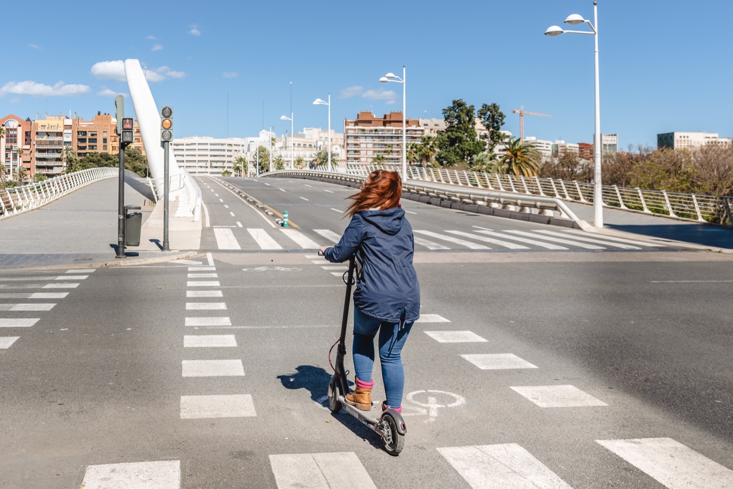 Mujer en patinete eléctrico montando por los carriles bici de valencia